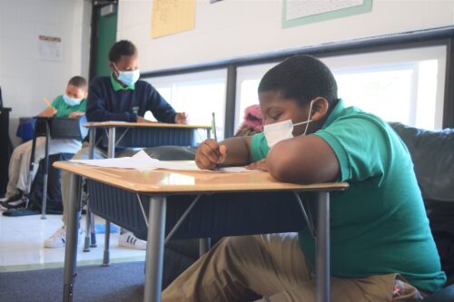 Students working in class while wearing masks, circa 2020